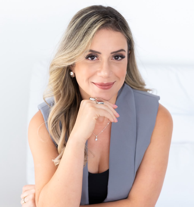 Dra. Karina Nabor sorrindo, com a mão no queixo